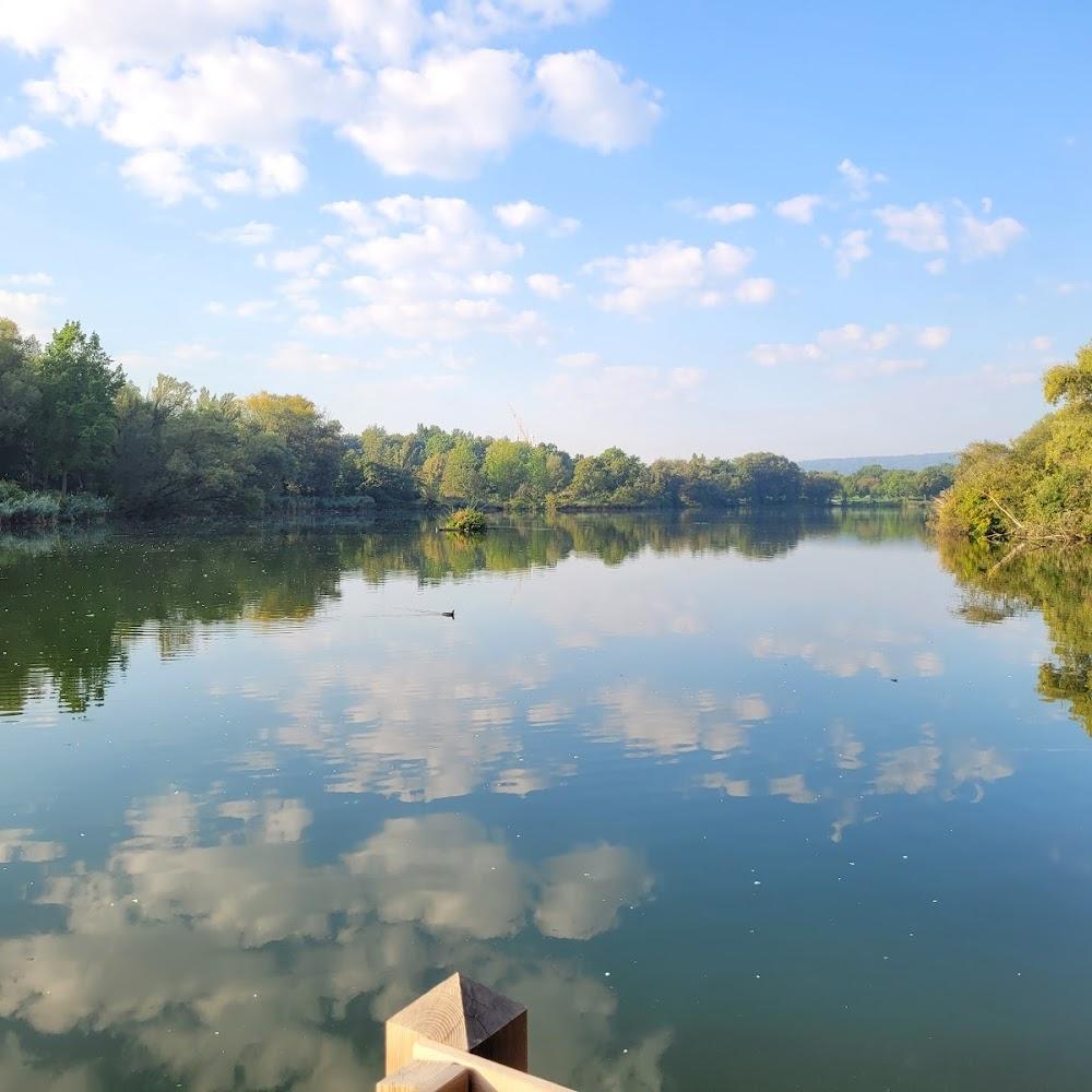 A calm lake with clouds reflecting on the surface.